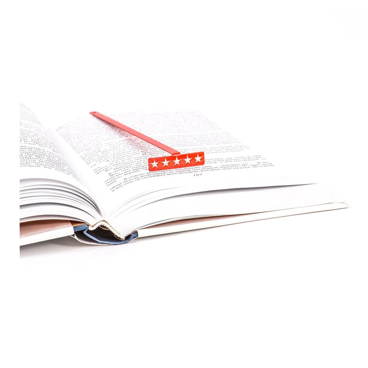 Five Star Bestseller metal bookmark in red resting on the pages of an open book
