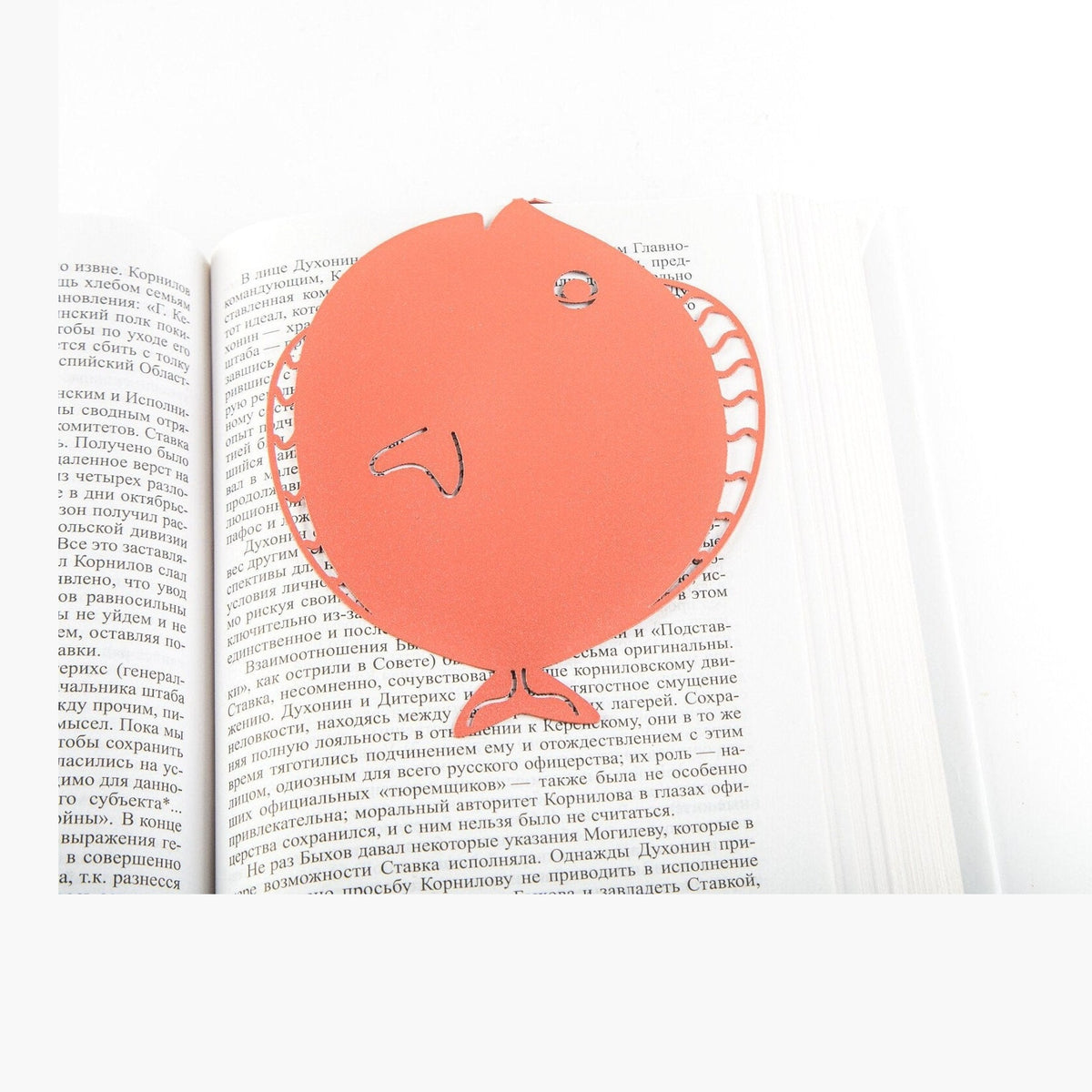 Flounder metal bookmark in red resting on the pages of an open book