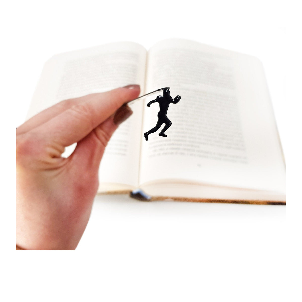 Football Player metal bookmark held in a hand above an open book