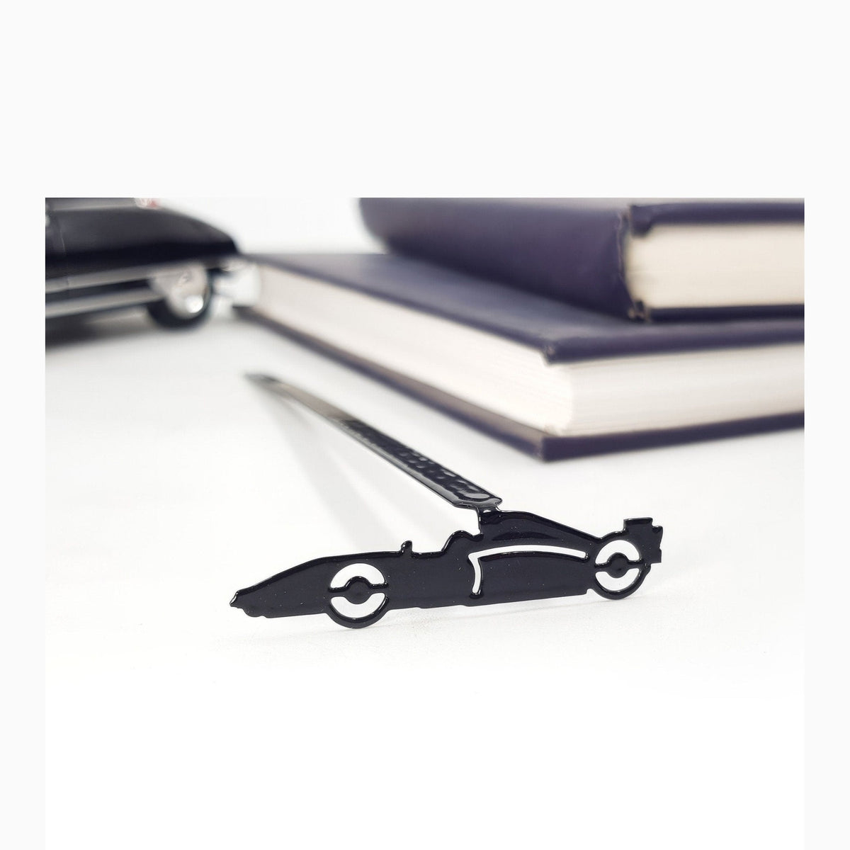 Formula One Indy Car metal bookmark shown with a stack of books