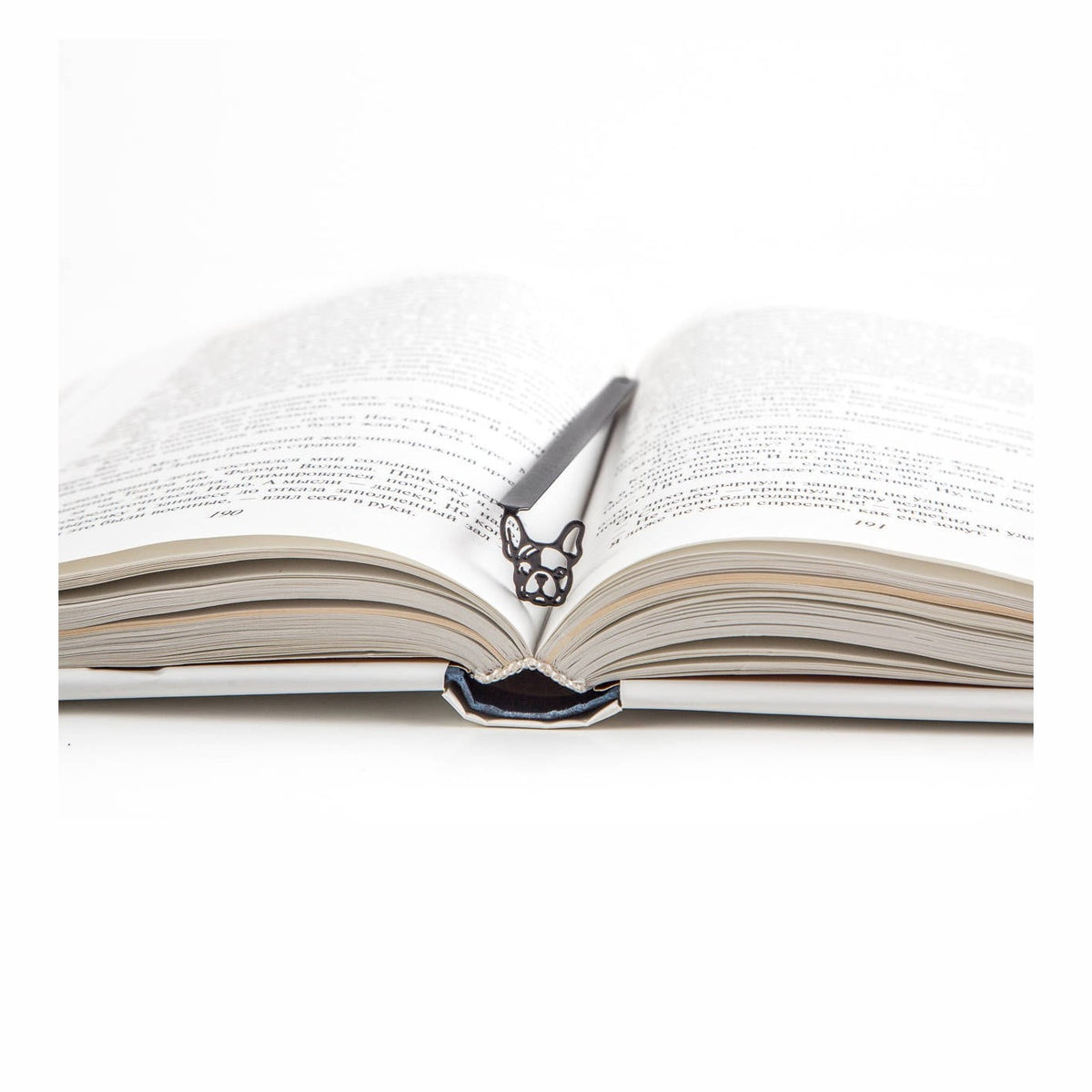 French Bulldog metal bookmark resting on the pages of an open book
