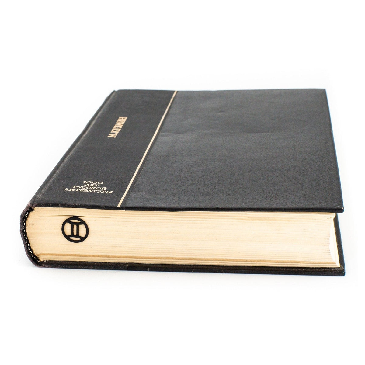 Gemini metal bookmark in a closed book, only its top showing above the pages