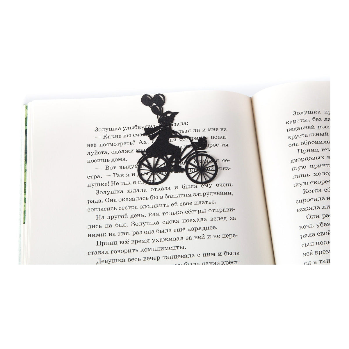 Girl on the Bike with Balloons metal bookmark resting on the pages of an open book