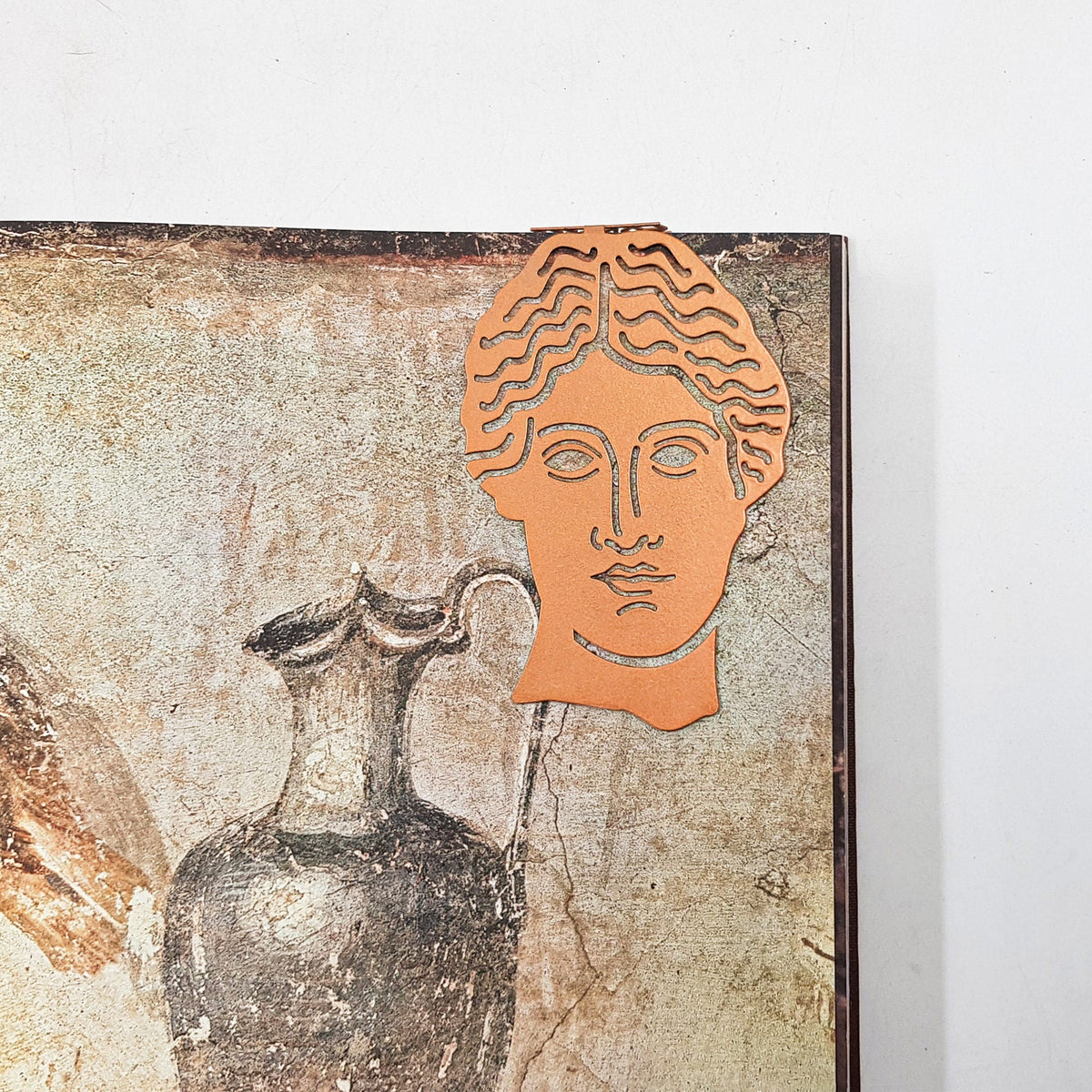 Goddess of Words metal bookmark in red on an illustrated page