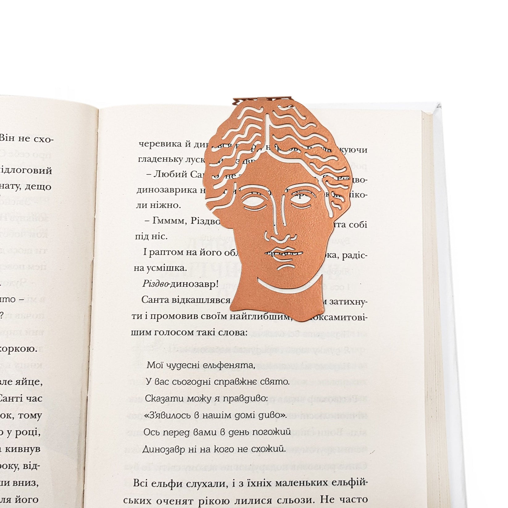 Goddess of Words metal bookmark in red resting on the pages of an open book