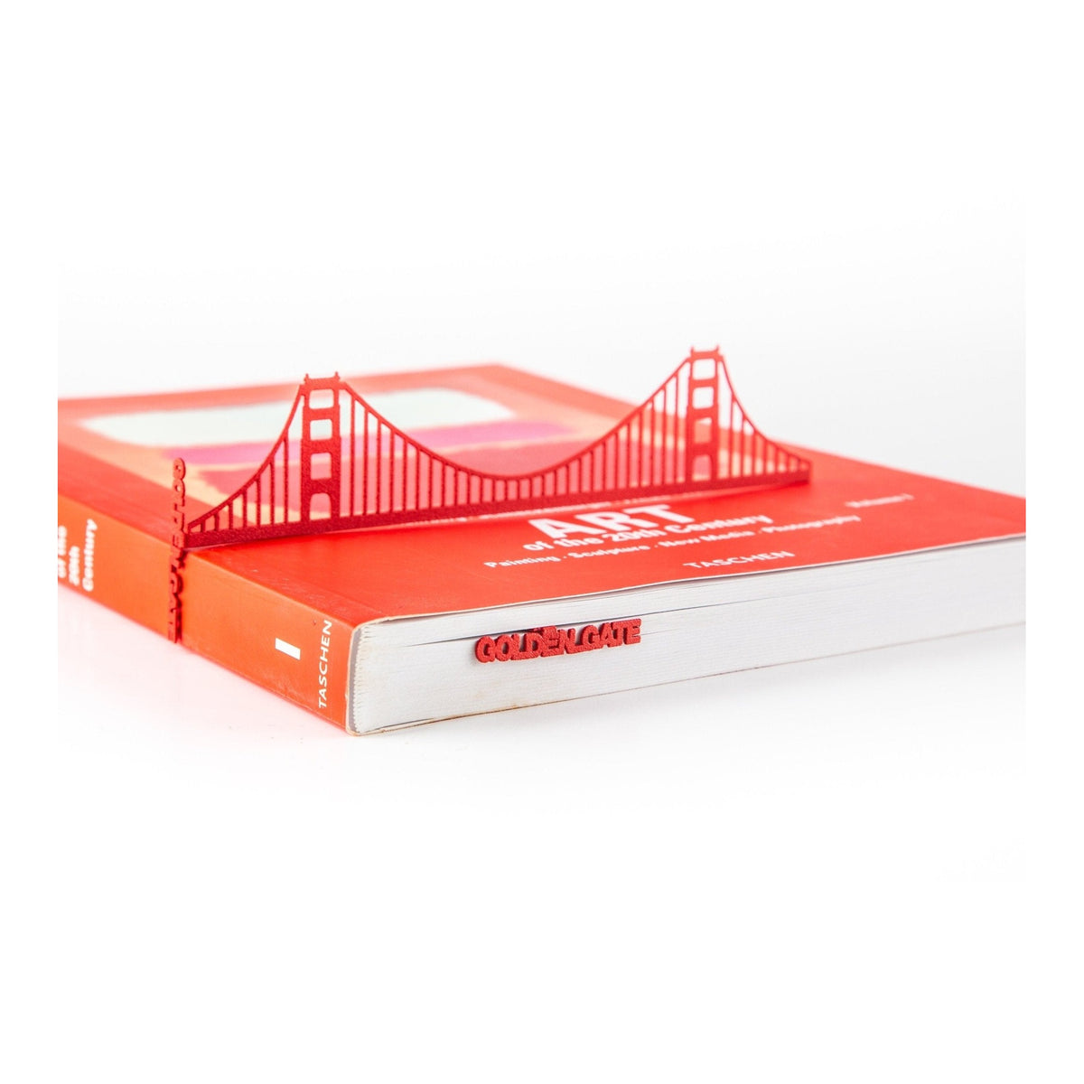 Golden Gate Bridge metal bookmark in red in a closed book, only its top showing above the pages