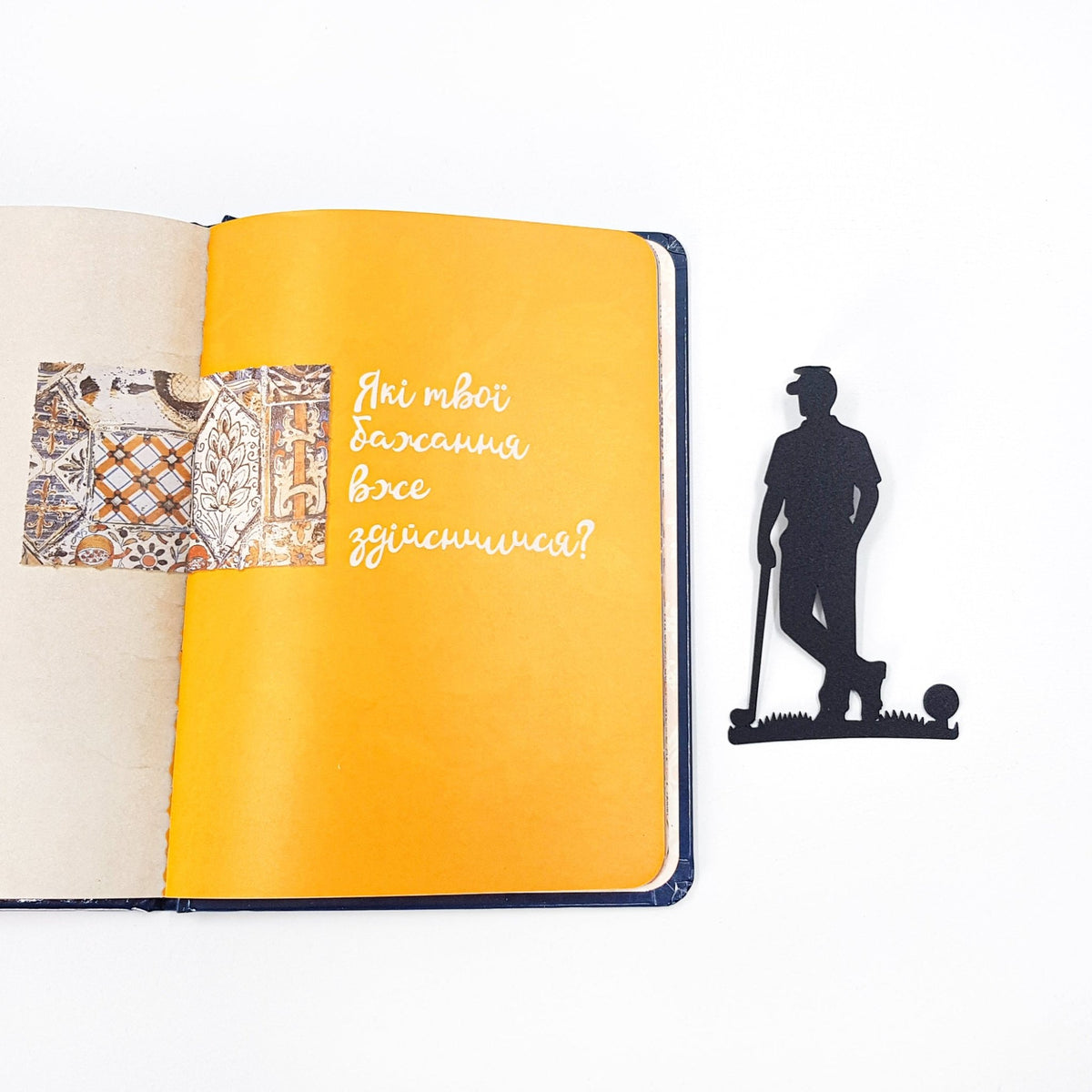 Golf Player metal bookmark marking a page in a notebook
