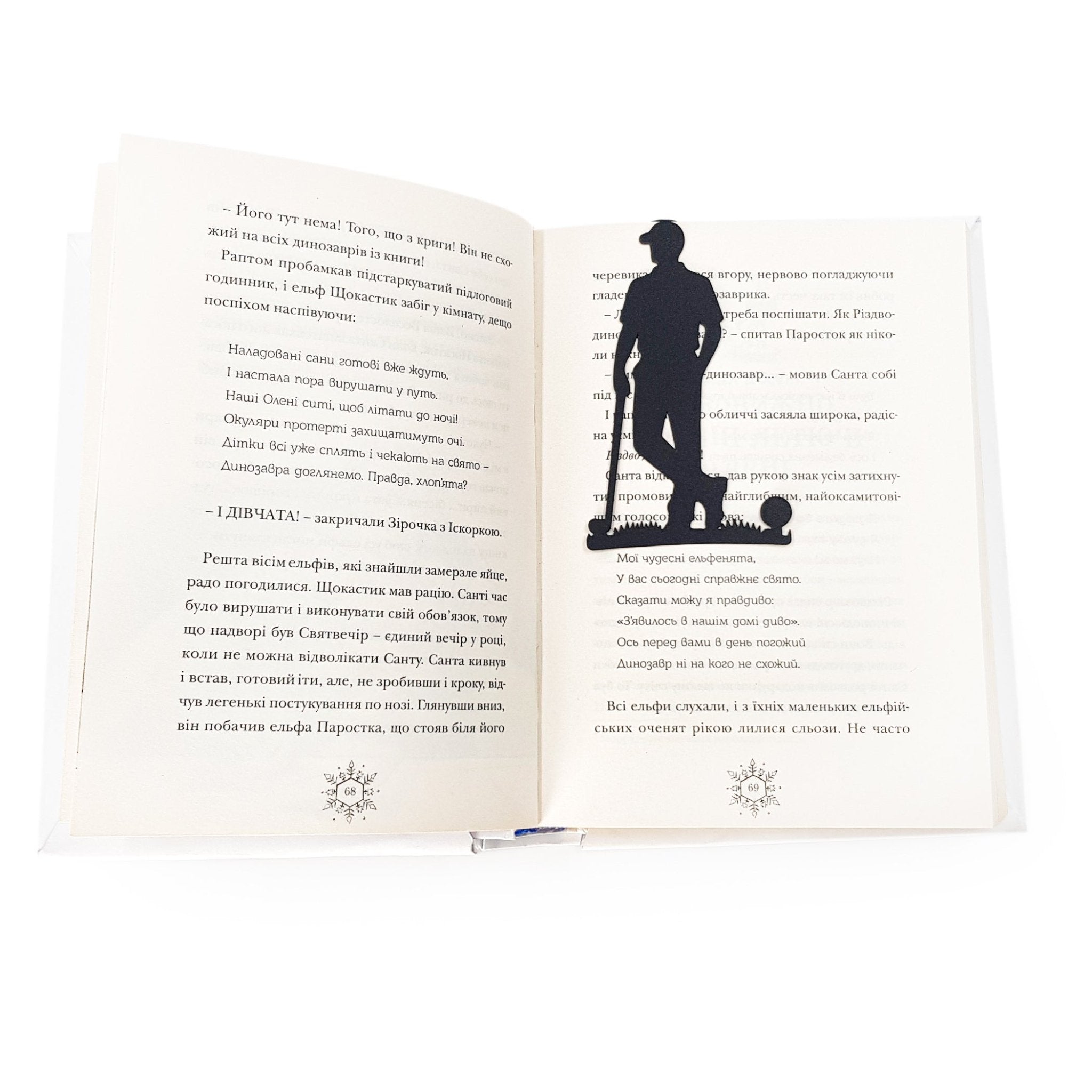 Black metal golf player bookmark placed between the pages of an open book, marking the reading page.