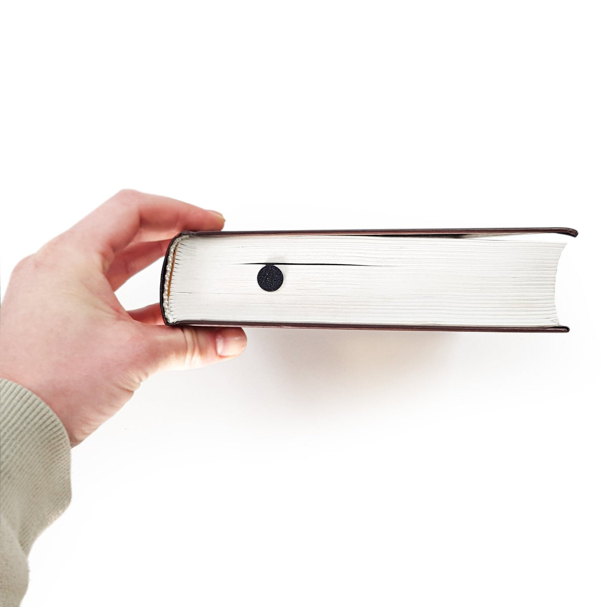 Golf Player metal bookmark held up beside an open book