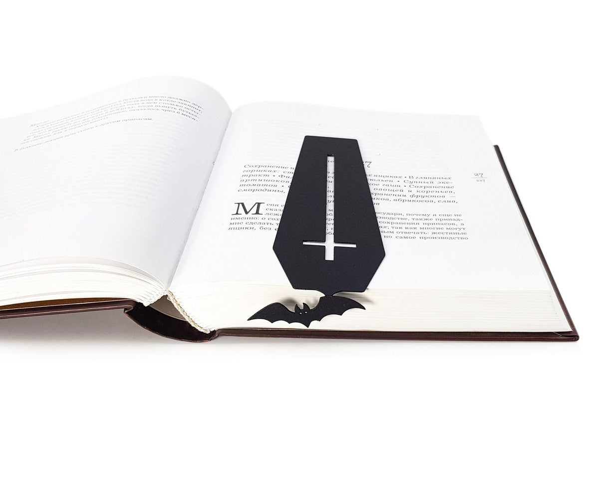 Gothic Coffin in My Book metal bookmark lying across the pages of an open book