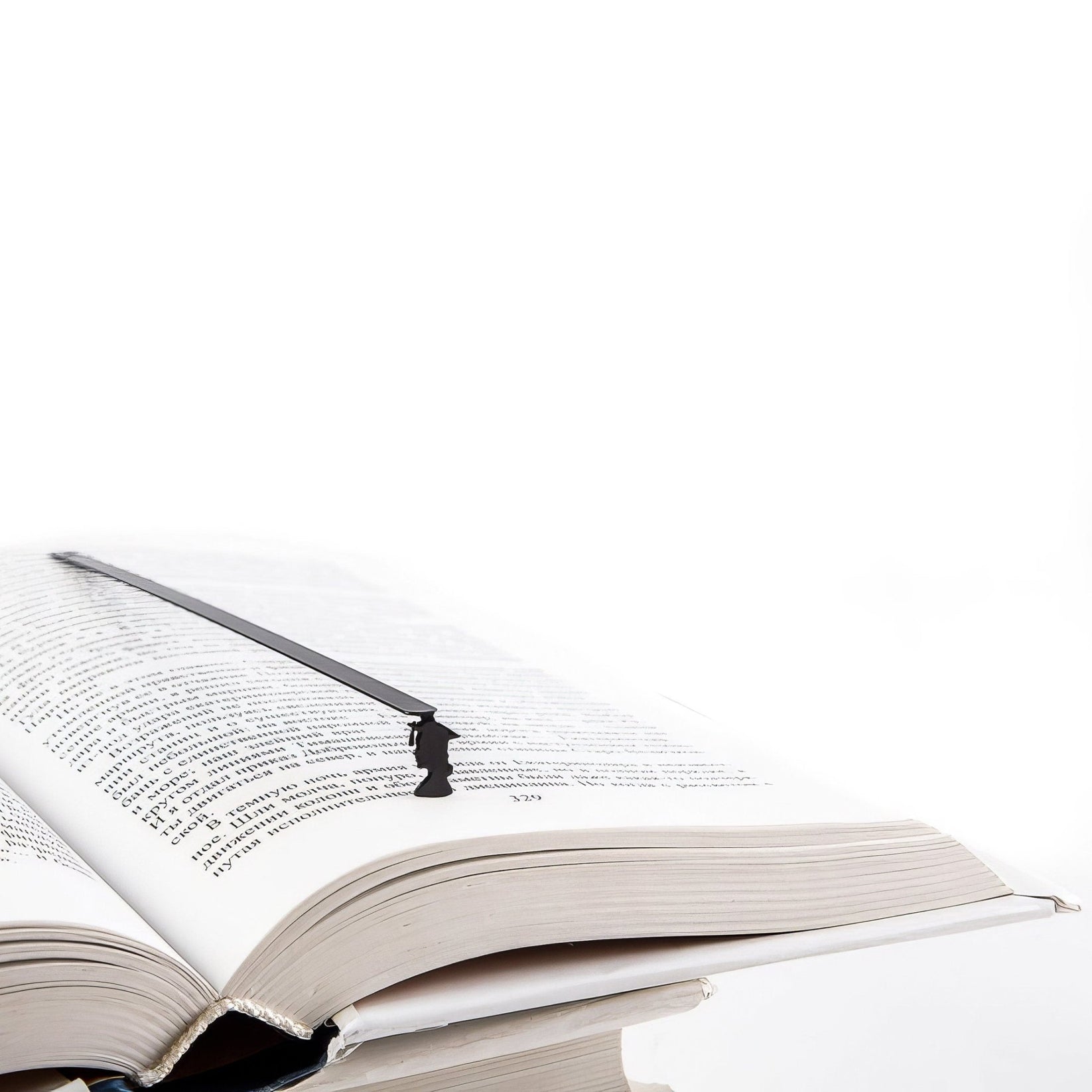 Graduate metal bookmark resting on the pages of an open book