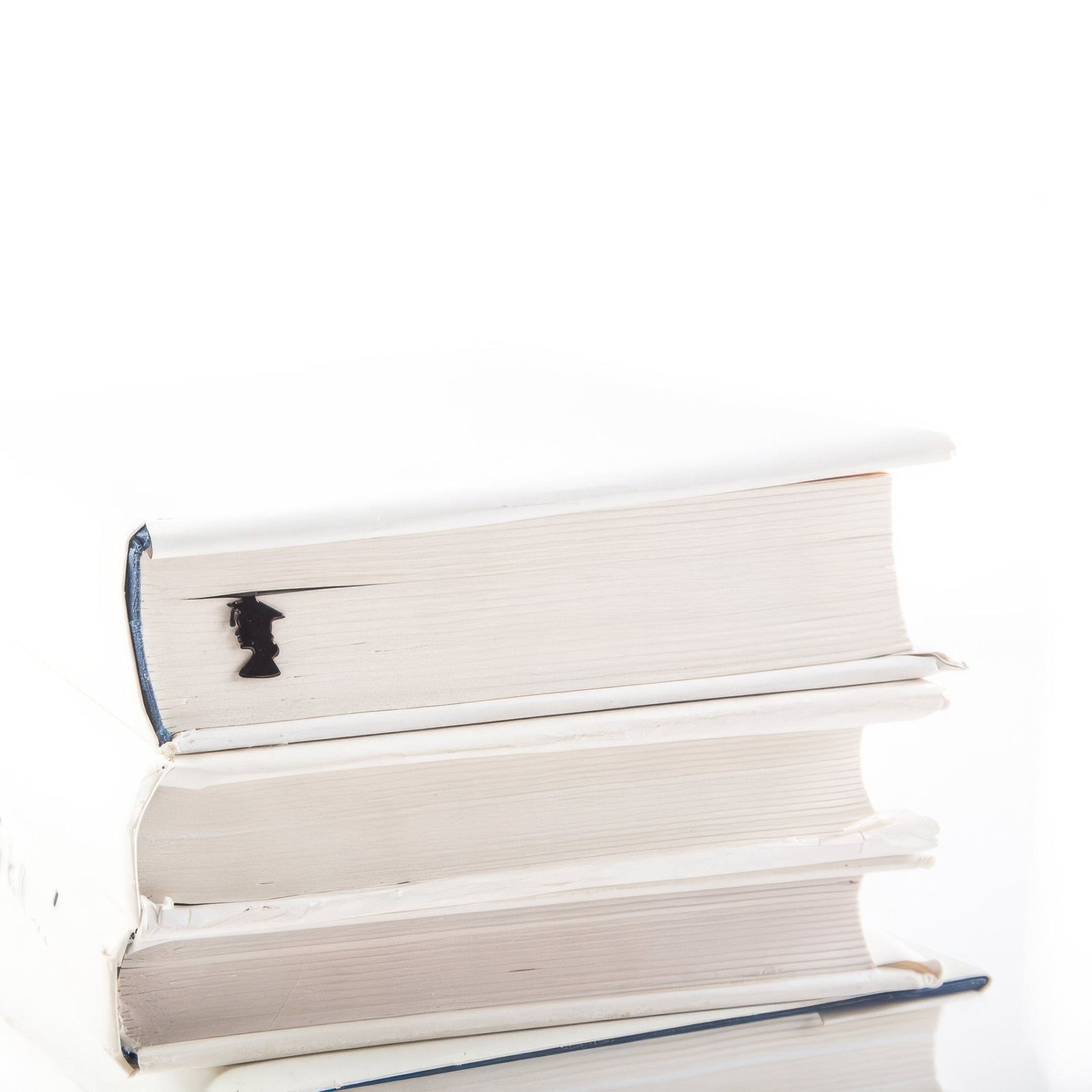 Graduate metal bookmark shown with a stack of books