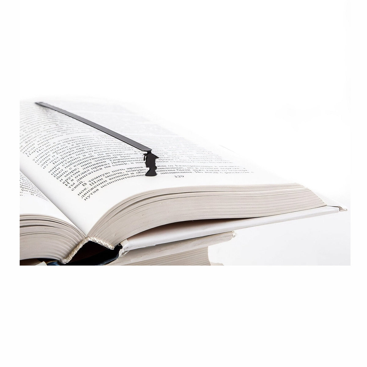 Graduate metal bookmark resting on the pages of an open book
