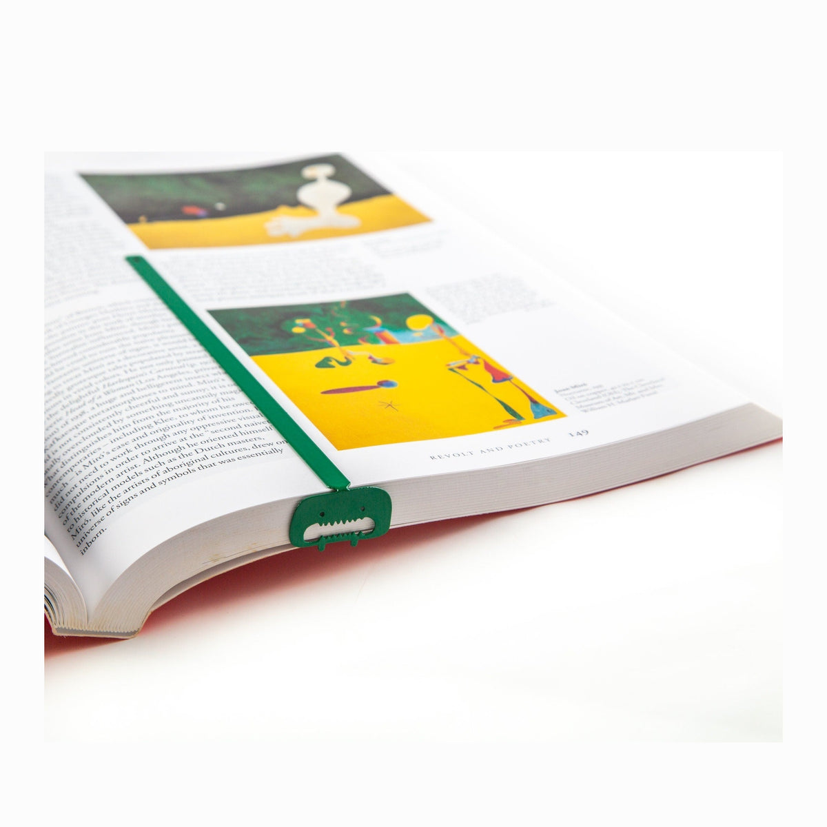 Green Screaming Monster metal bookmark marking a page in an illustrated book