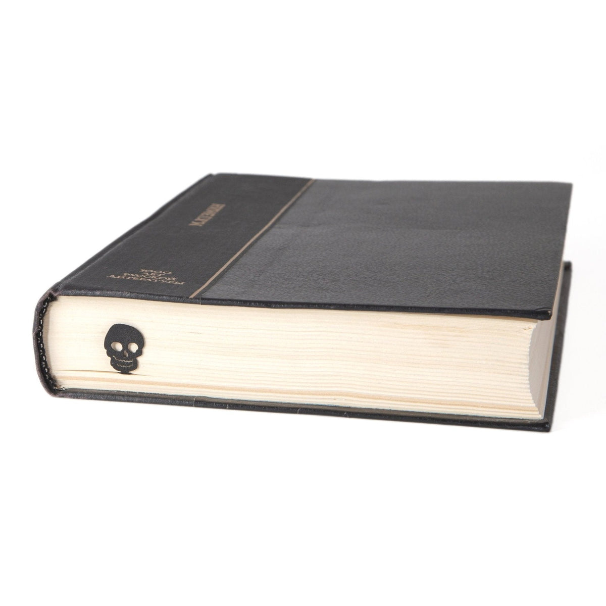 Grinning Skull metal bookmark in a closed book, only its top showing above the pages