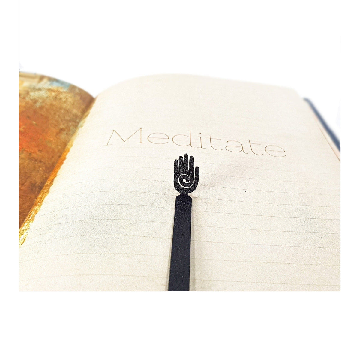 Healing Hand metal bookmark resting on the pages of an open book