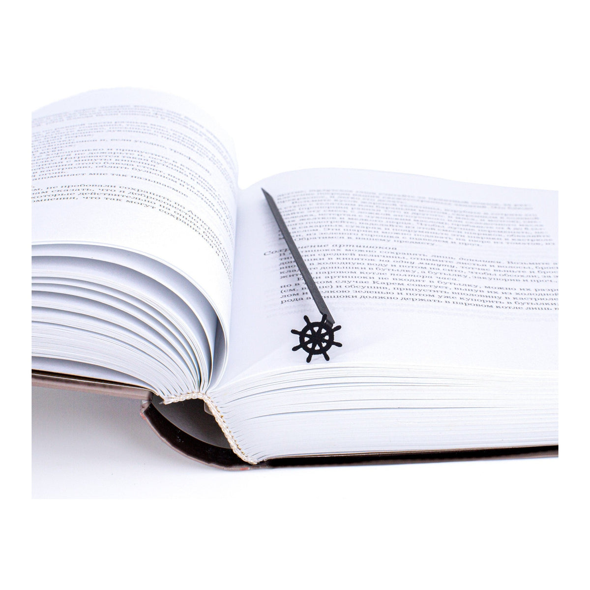 Helm metal bookmark resting on the pages of an open book