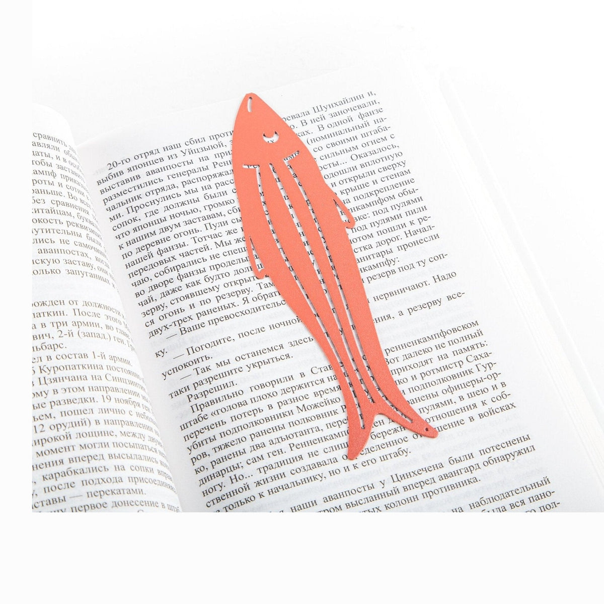 Herring metal bookmark in red resting on the pages of an open book