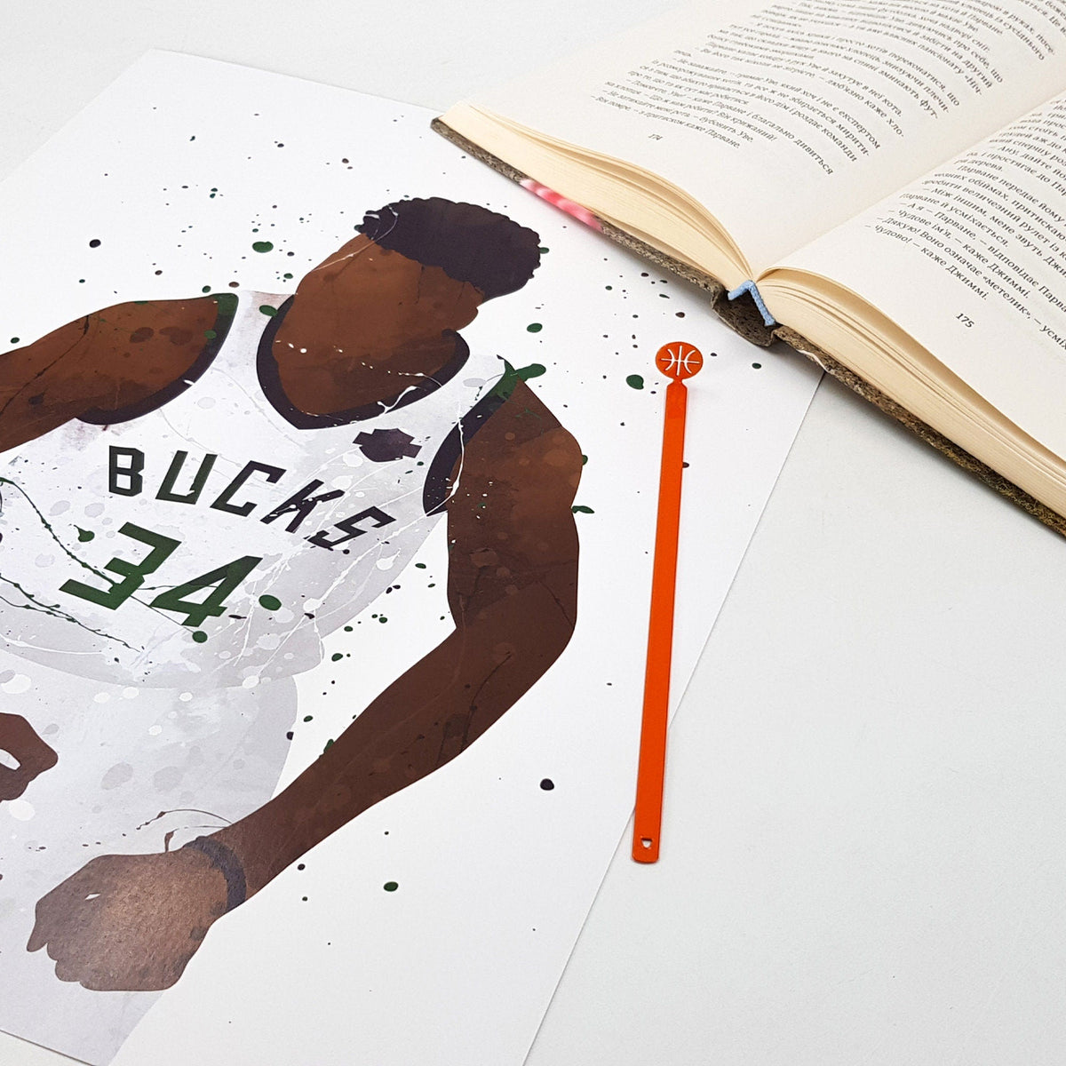 Hoop Dreams Mark metal bookmark in red on an illustrated page