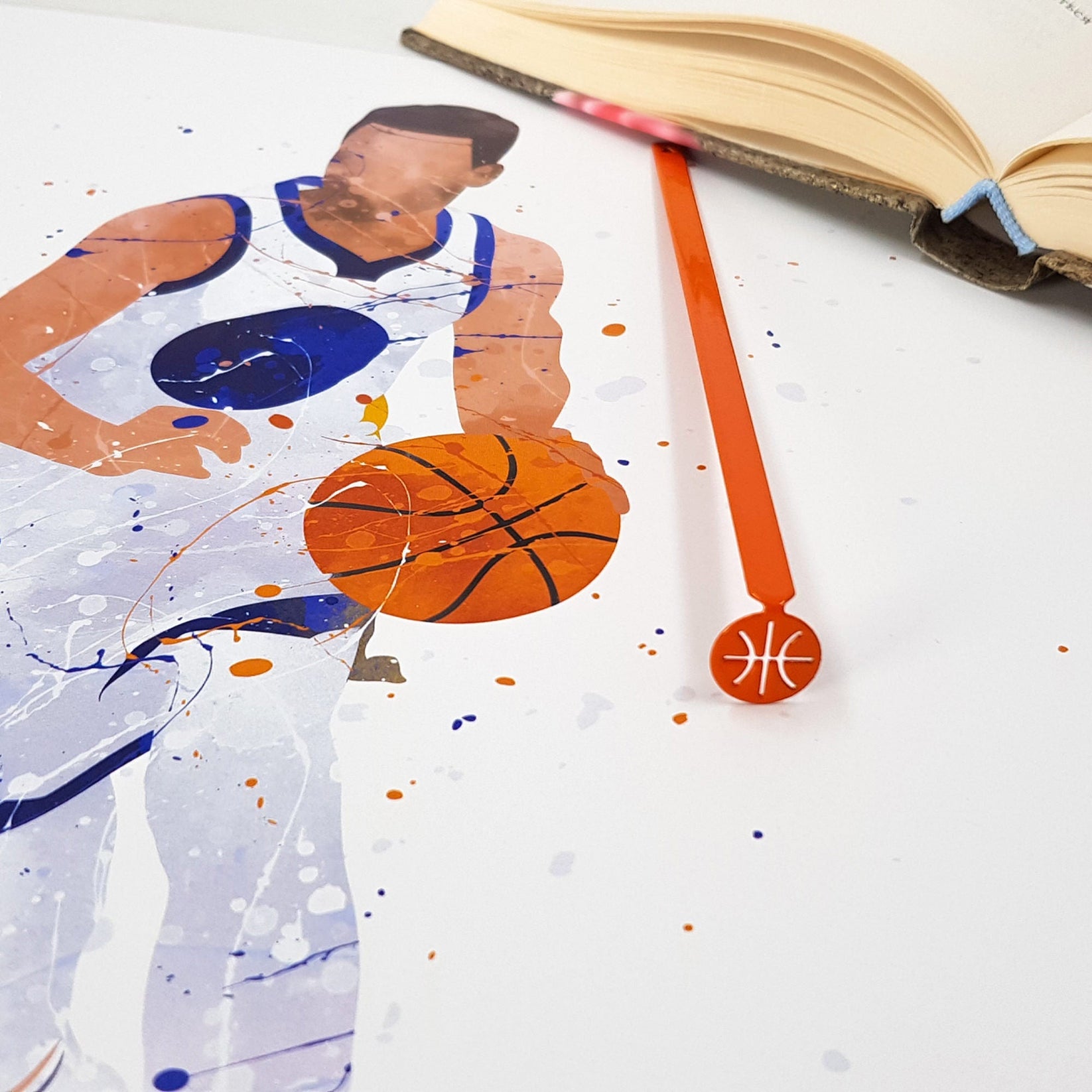 Hoop Dreams Mark metal bookmark in red placed on a colour illustration