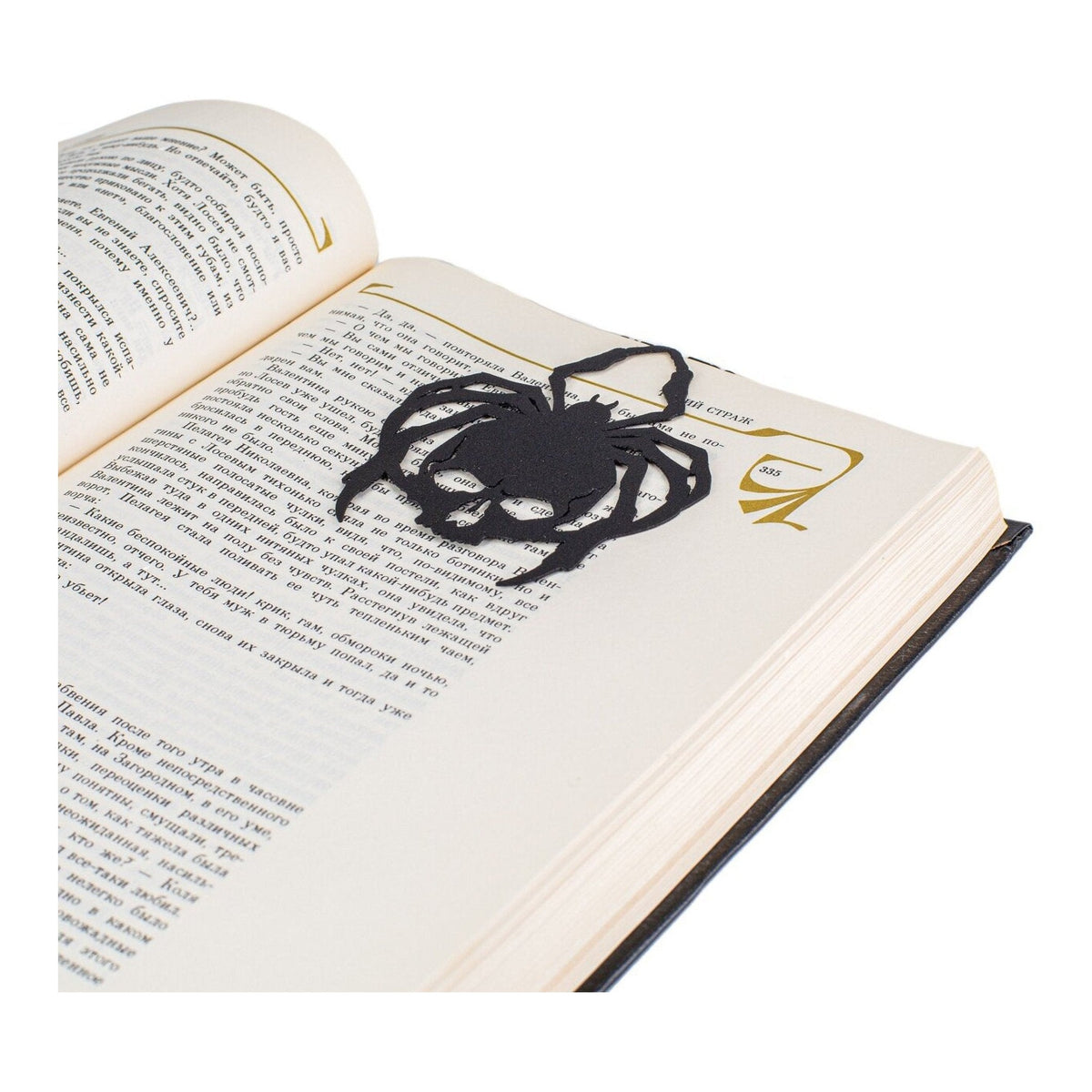 Horror Skull Spider metal bookmark resting on the pages of an open book
