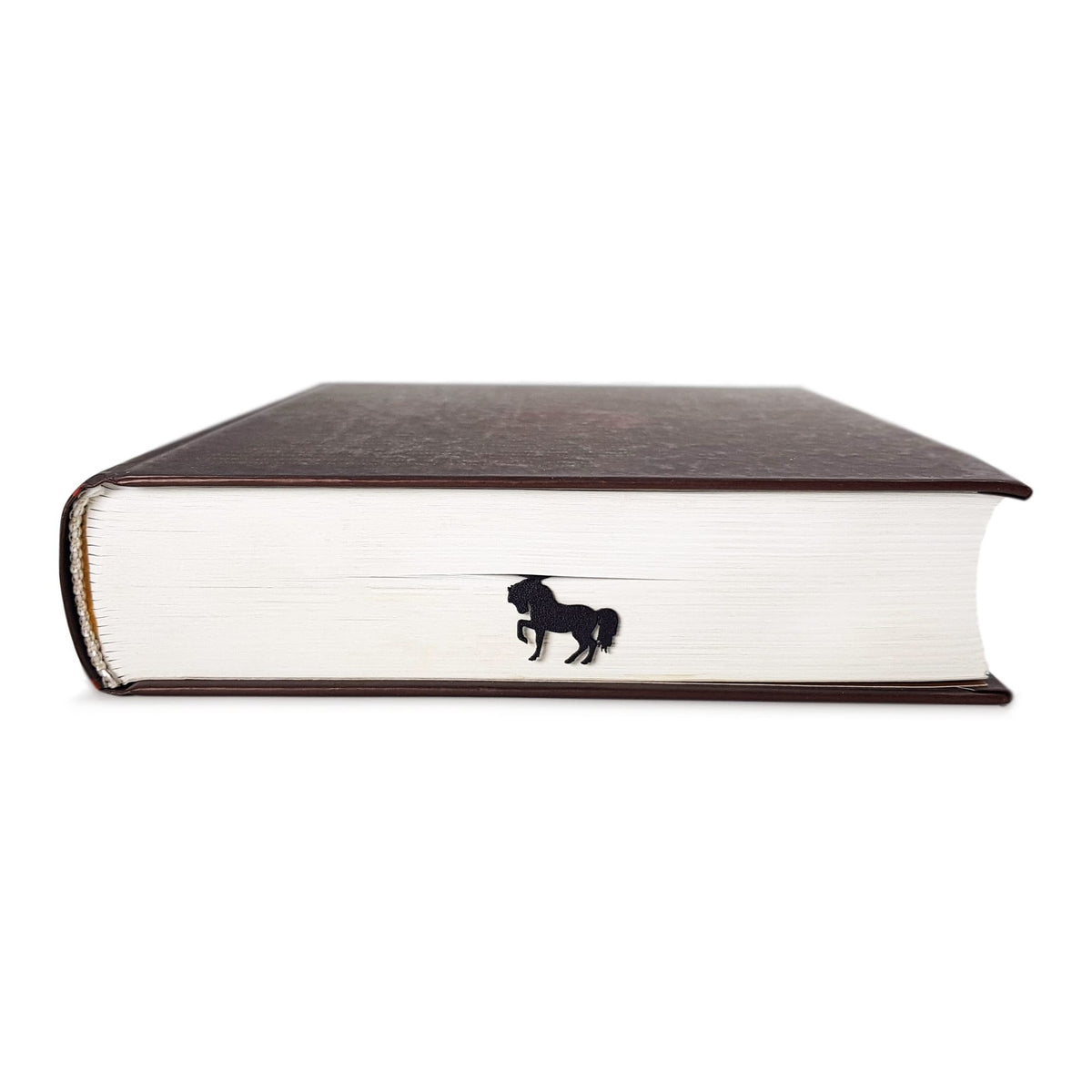 Horse metal bookmark in a closed book, only its top showing above the pages