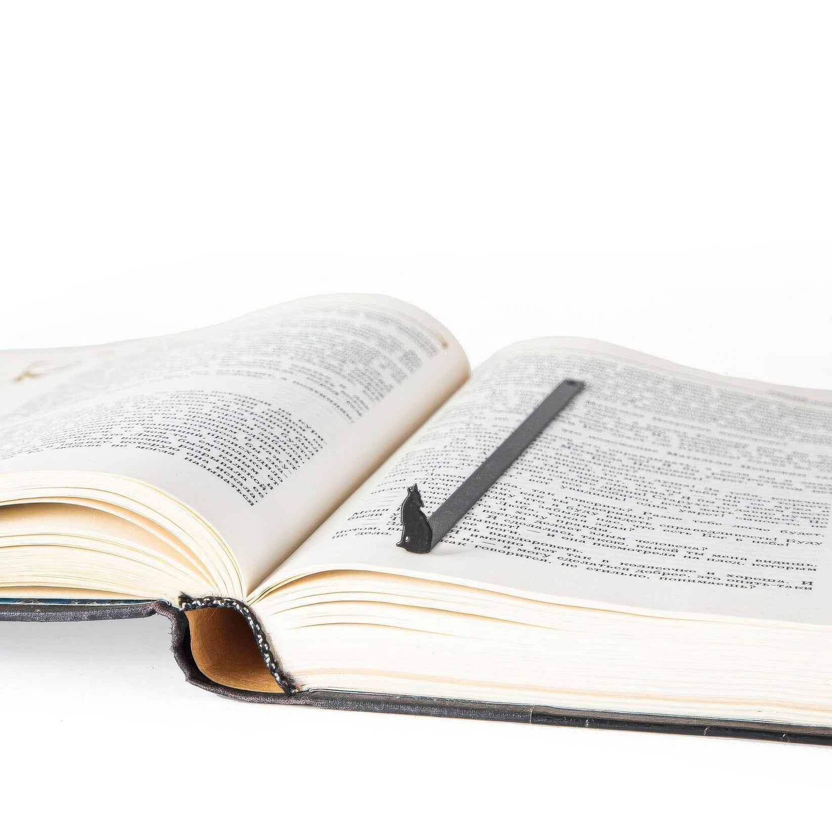 Howling Wolf metal bookmark marking a page in an open book