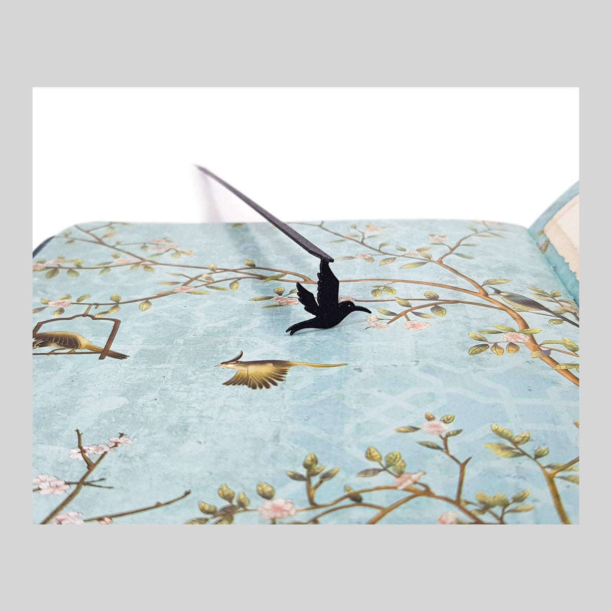 Hummingbird metal bookmark on a coloured background