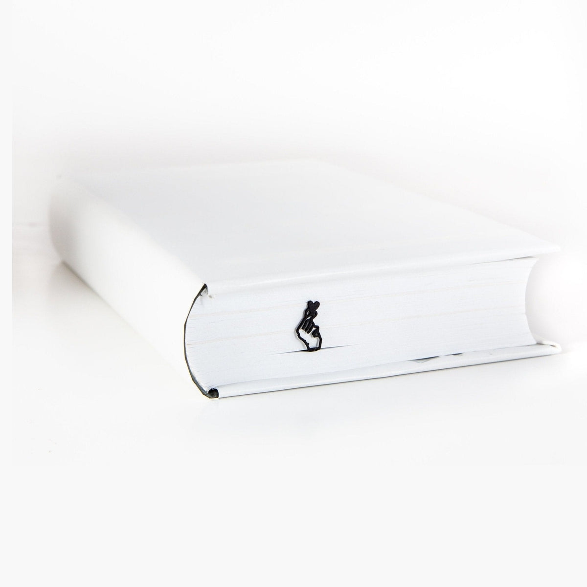I Am Giving You My Heart metal bookmark in a closed book, only its top showing above the pages