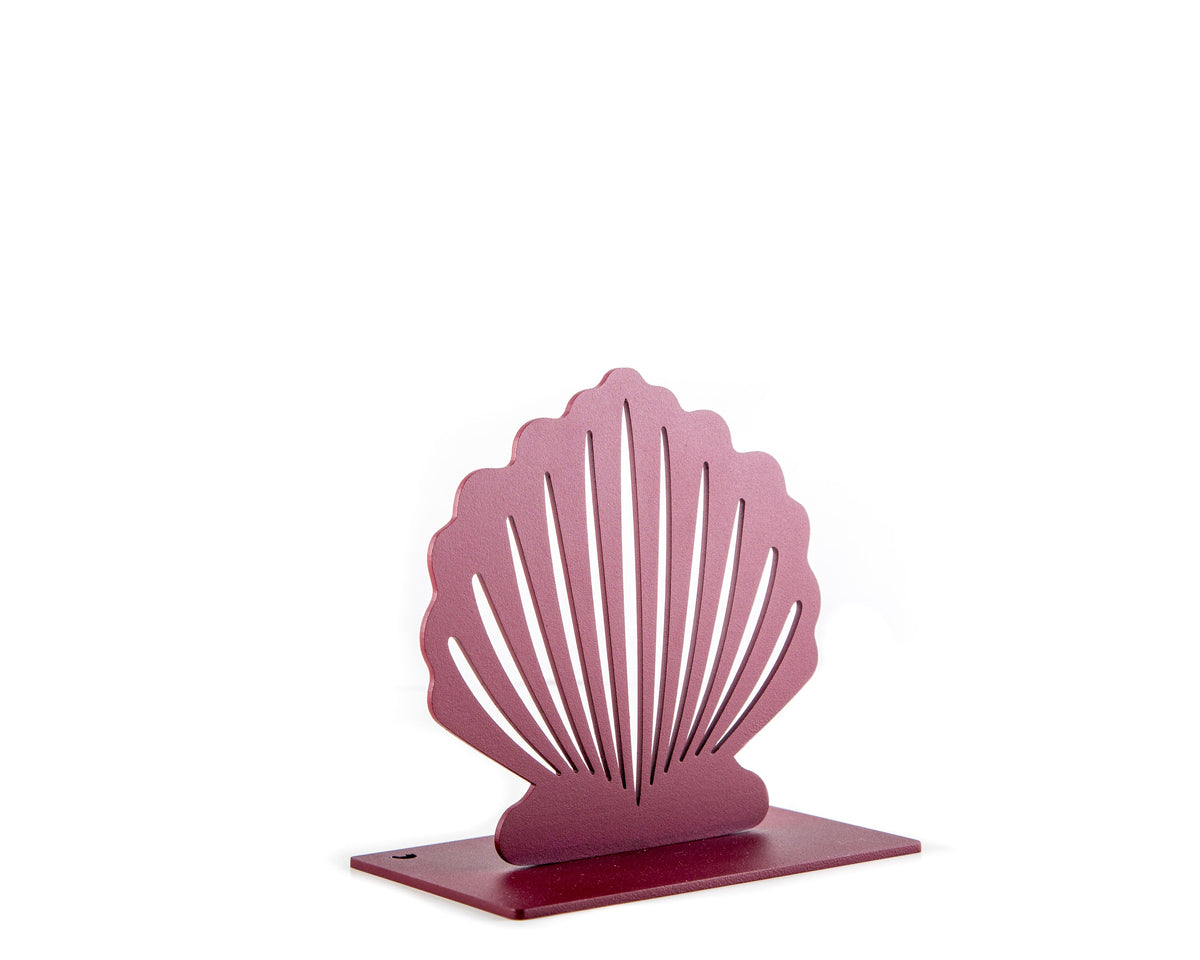 Angled view of a single red metal seashell-shaped bookend with clean cutout lines and a smooth matte finish, photographed on a white background.