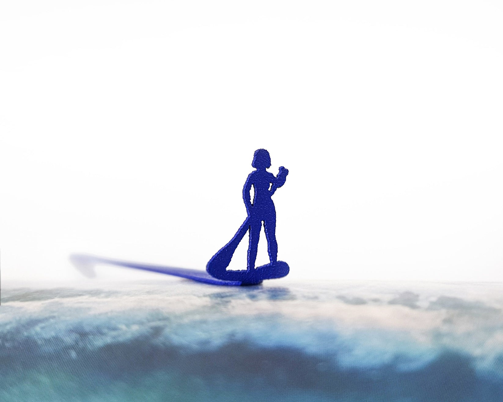 Surfer metal bookmark in blue on a coloured background