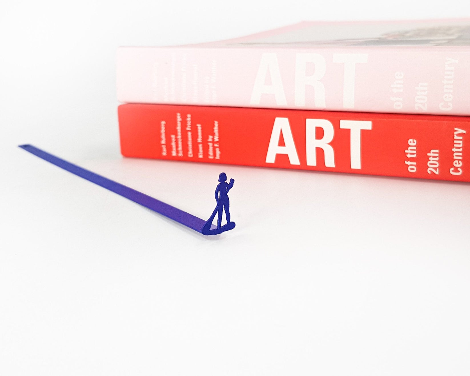 Surfer metal bookmark in blue in a closed book, only its top showing above the pages