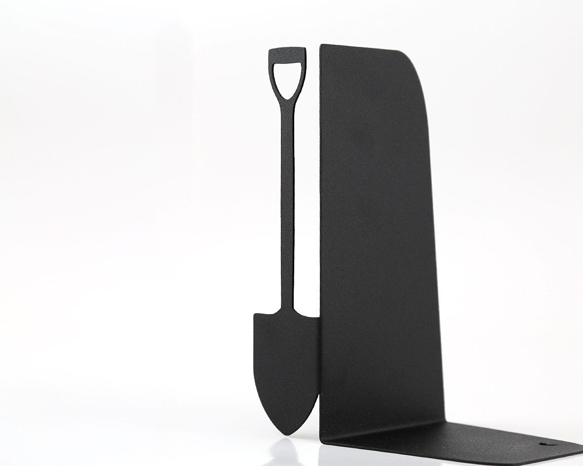 Close-up of black metal bookend featuring a cut-out garden shovel – minimalist matte finish with clean lines, ideal for garden-themed or rustic bookshelf decor. Sturdy and functional for everyday use.