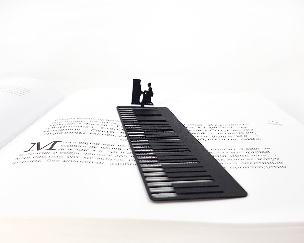 Piano Player metal bookmark resting on the pages of an open book, view 5