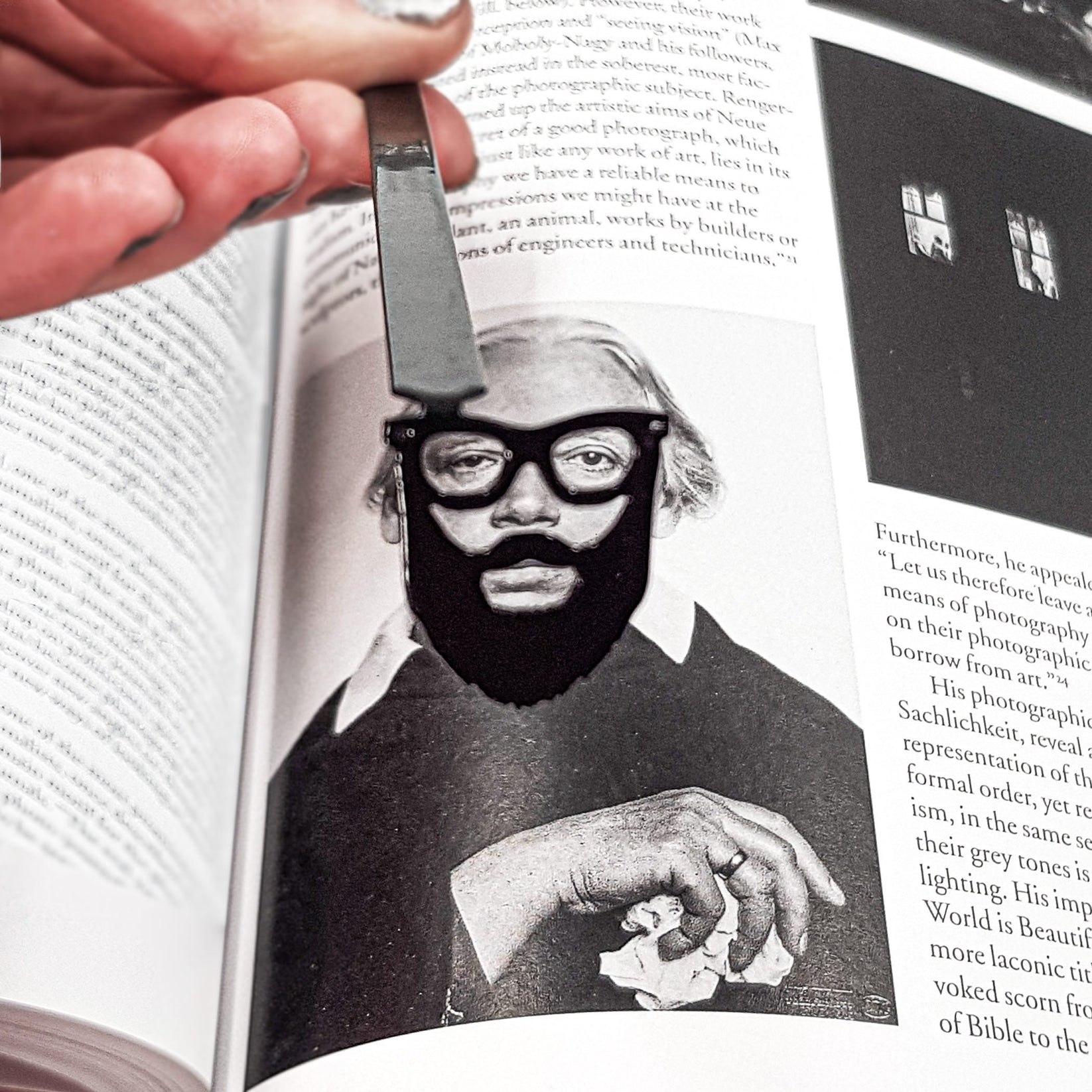 Hipster metal bookmark marking a page in an illustrated book, view 4