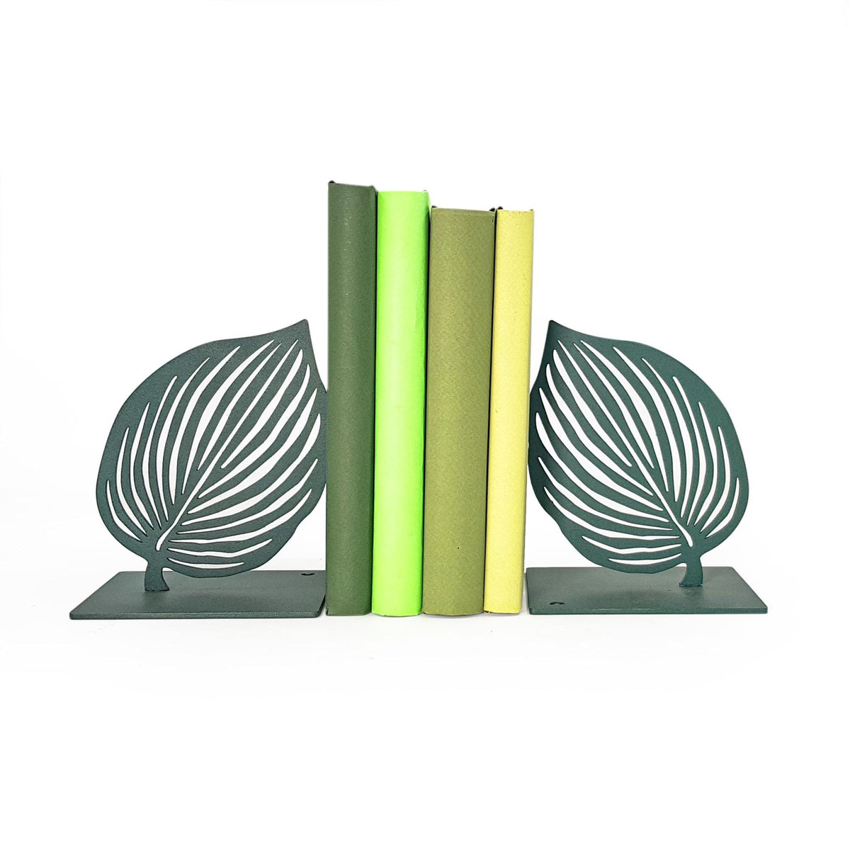 Green leaf metal bookends holding books, minimalist botanical bookends with leaf silhouettes and matte green finish on a shelf. Handcrafted in Cherkasy, Ukraine by Atelier Article. Not mass-produced.