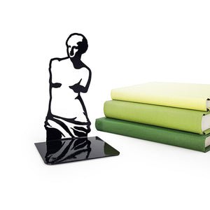 Black metal Venus de Milo bookend next to stacked green books, featuring a glossy finish and minimalist classical art silhouette design.