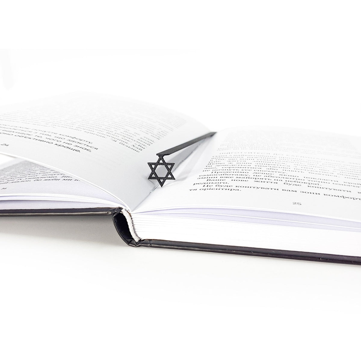 Judaical Star of David metal bookmark marking a page in an open book