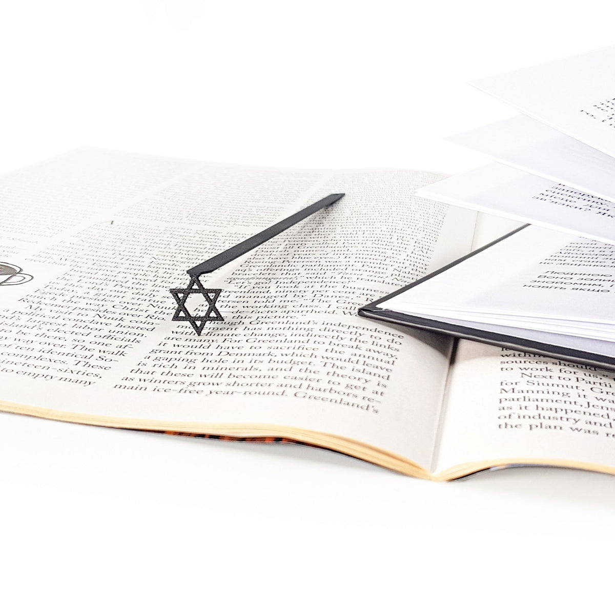 Judaical Star of David metal bookmark lying across the pages of an open book