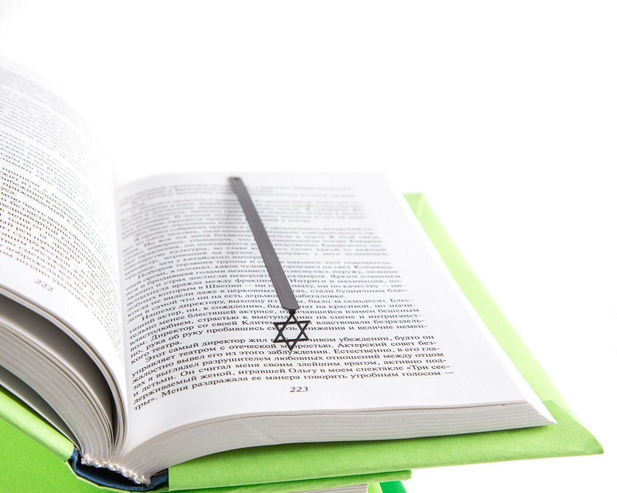 Judaical Star of David metal bookmark resting on the pages of an open book