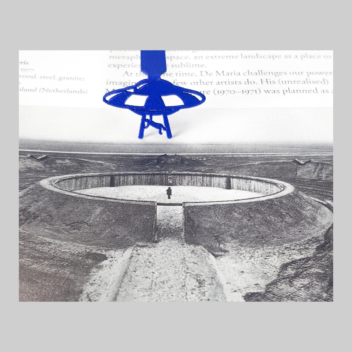 Kidnapped by UFO metal bookmark in blue marking a page in an illustrated book