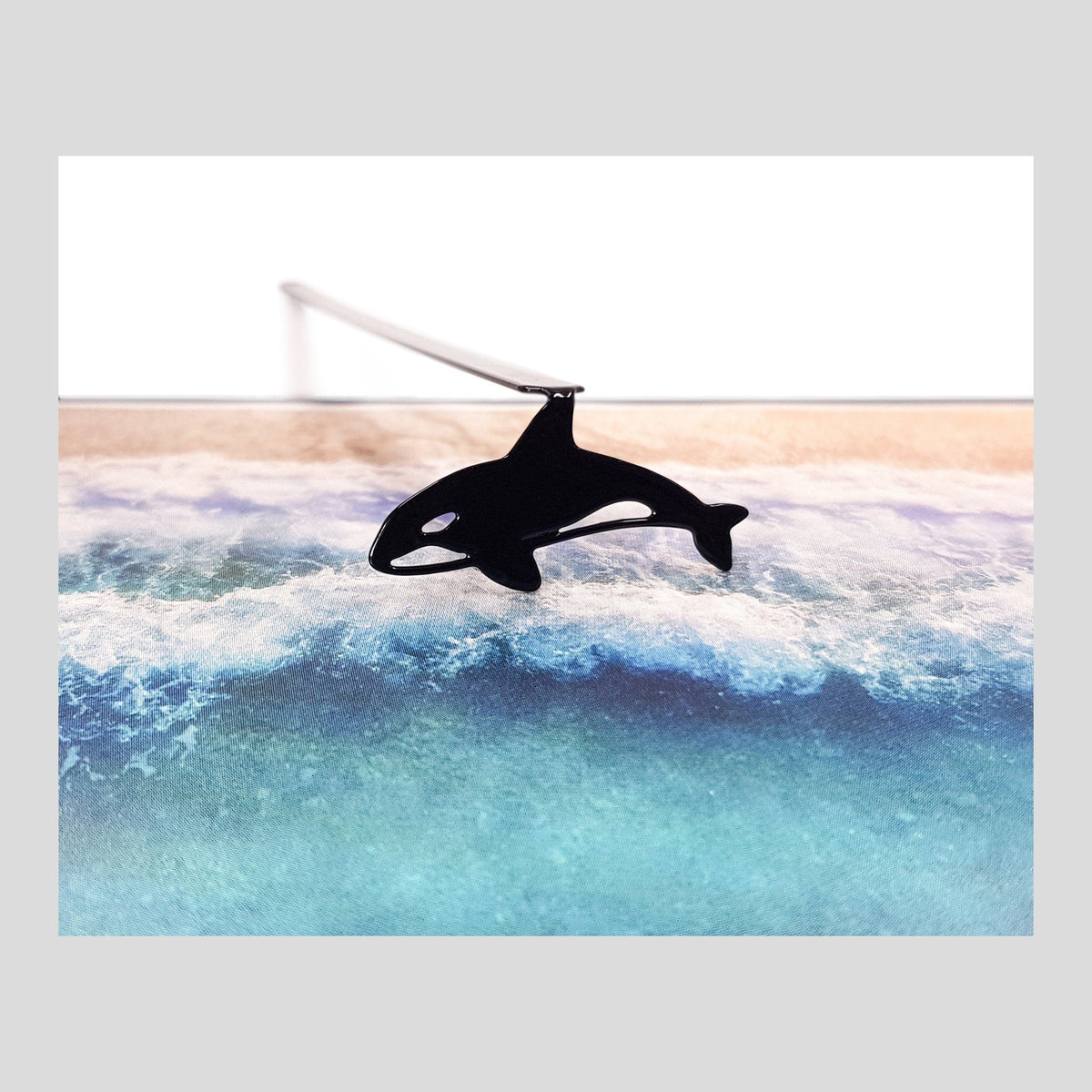 Killer Whale Orca metal bookmark marking a page in an illustrated book
