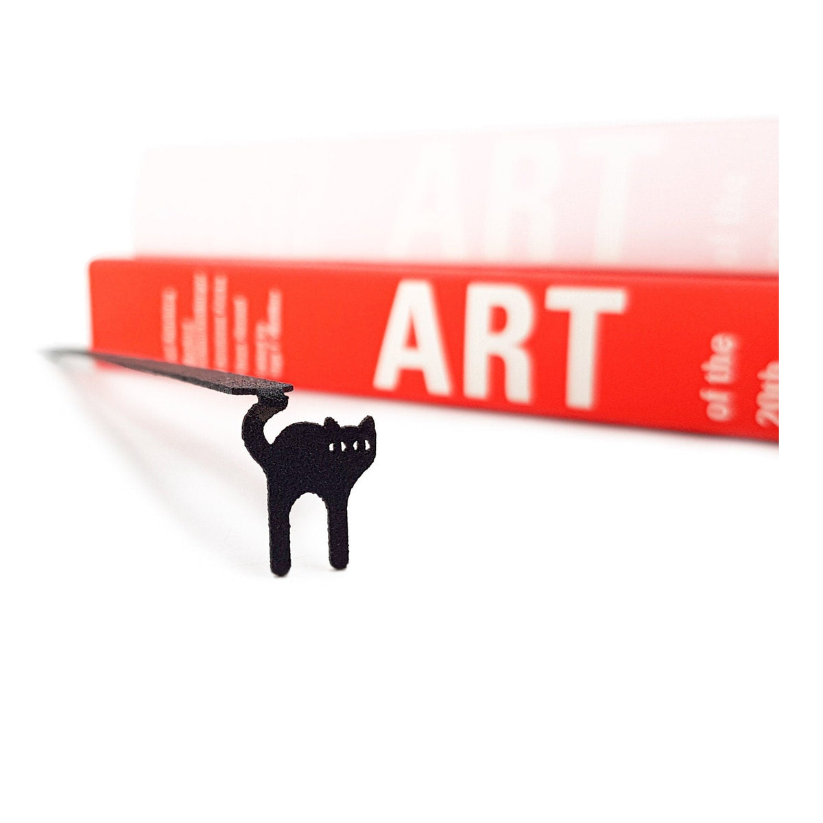 Kitty Grace metal bookmark in a closed book, only its top showing above the pages