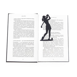 Black metal lady golf player bookmark standing inside an open book, marking the page with a slim silhouette design