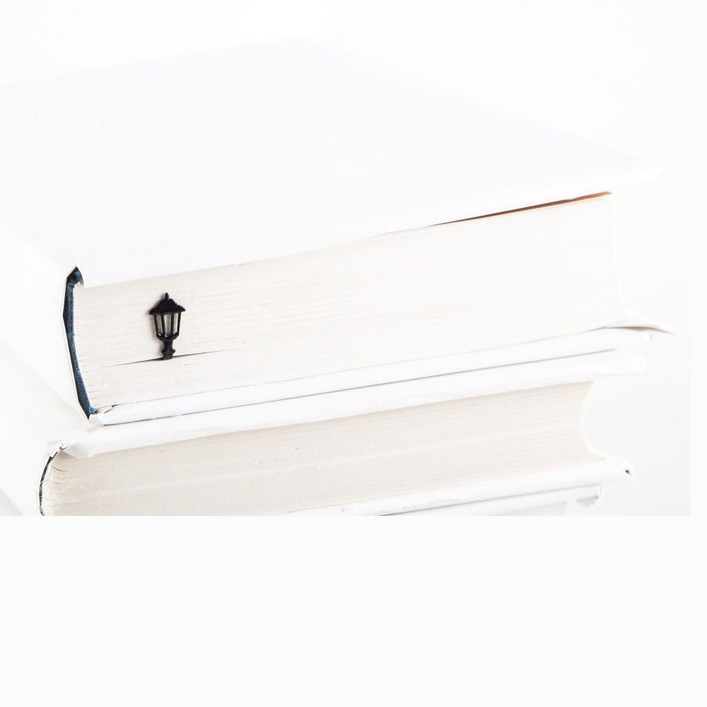 Lamppost metal bookmark in a closed book, only its top showing above the pages
