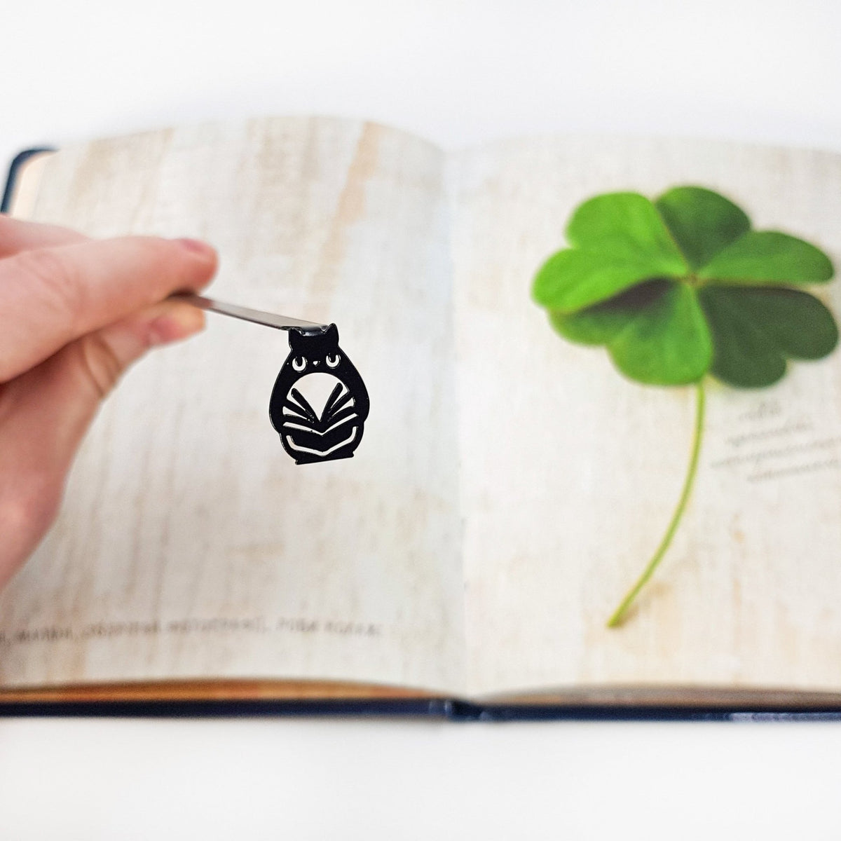 Laser Cut Metal Owl bookmark resting on the pages of an open book