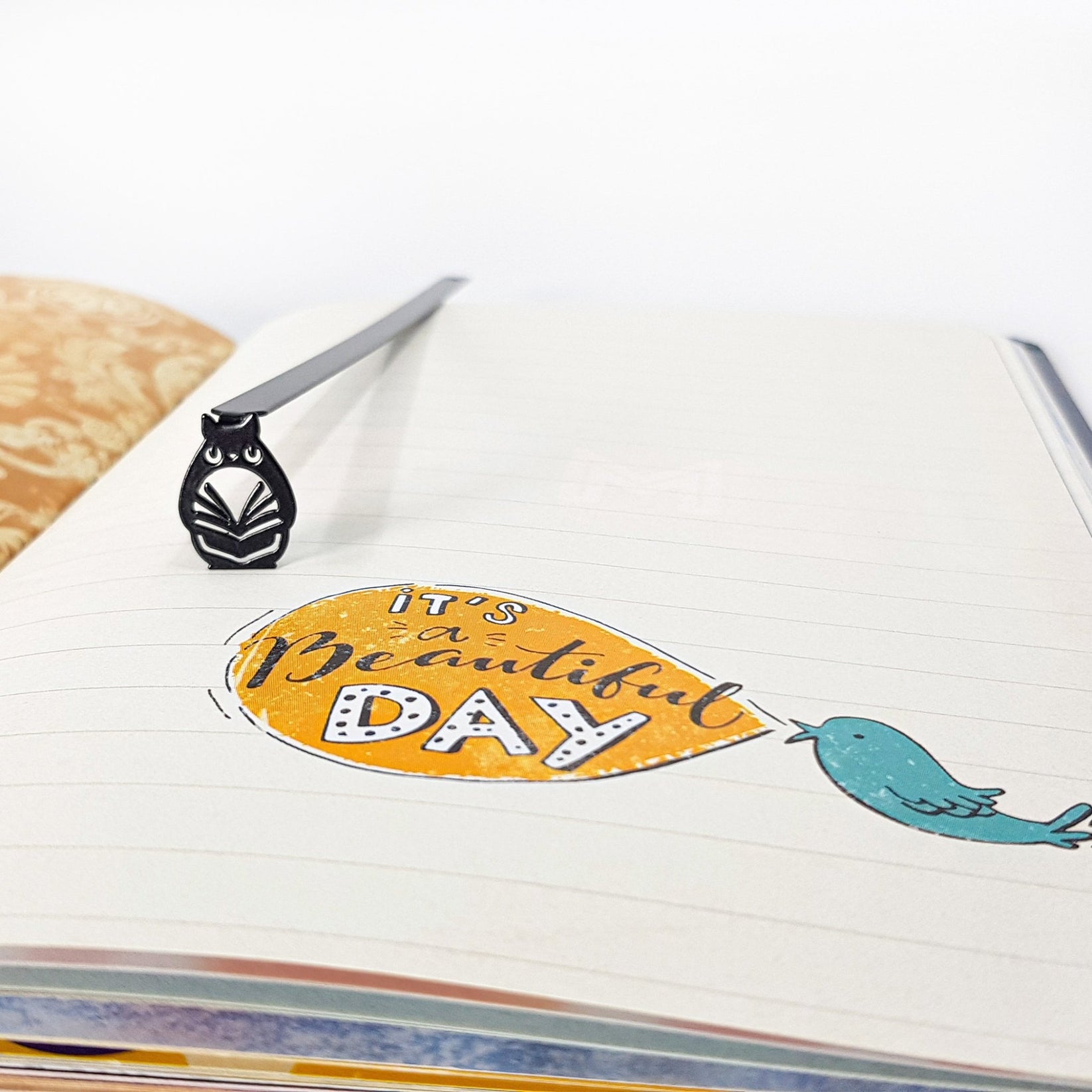 Laser Cut Metal Owl bookmark on an illustrated page