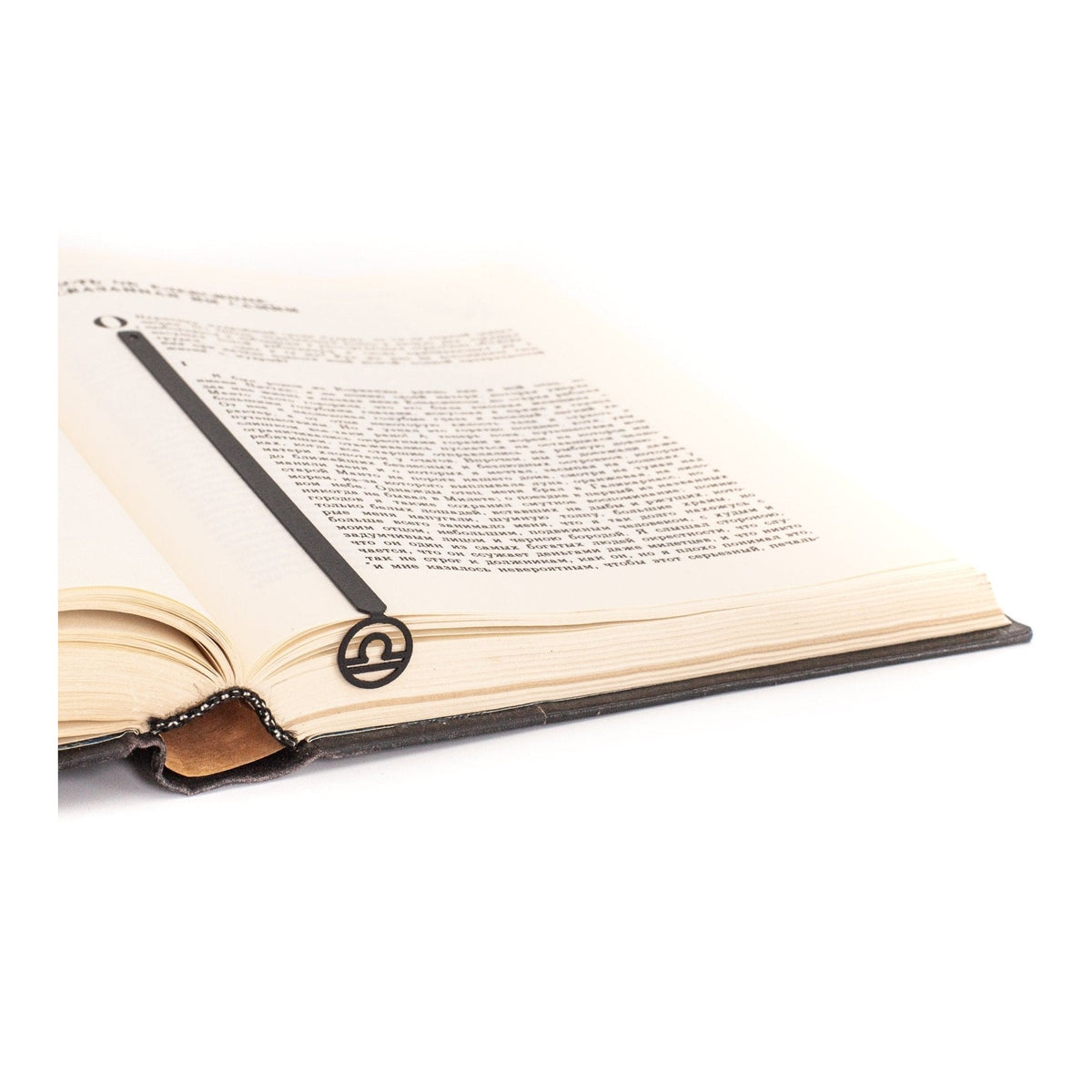 Libra metal bookmark resting on the pages of an open book