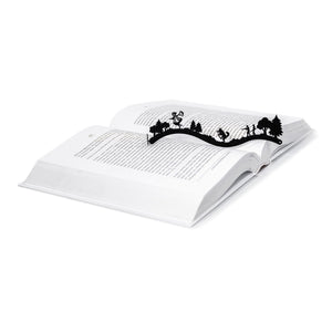 Little Red Riding Hood metal bookmark resting on the pages of an open book