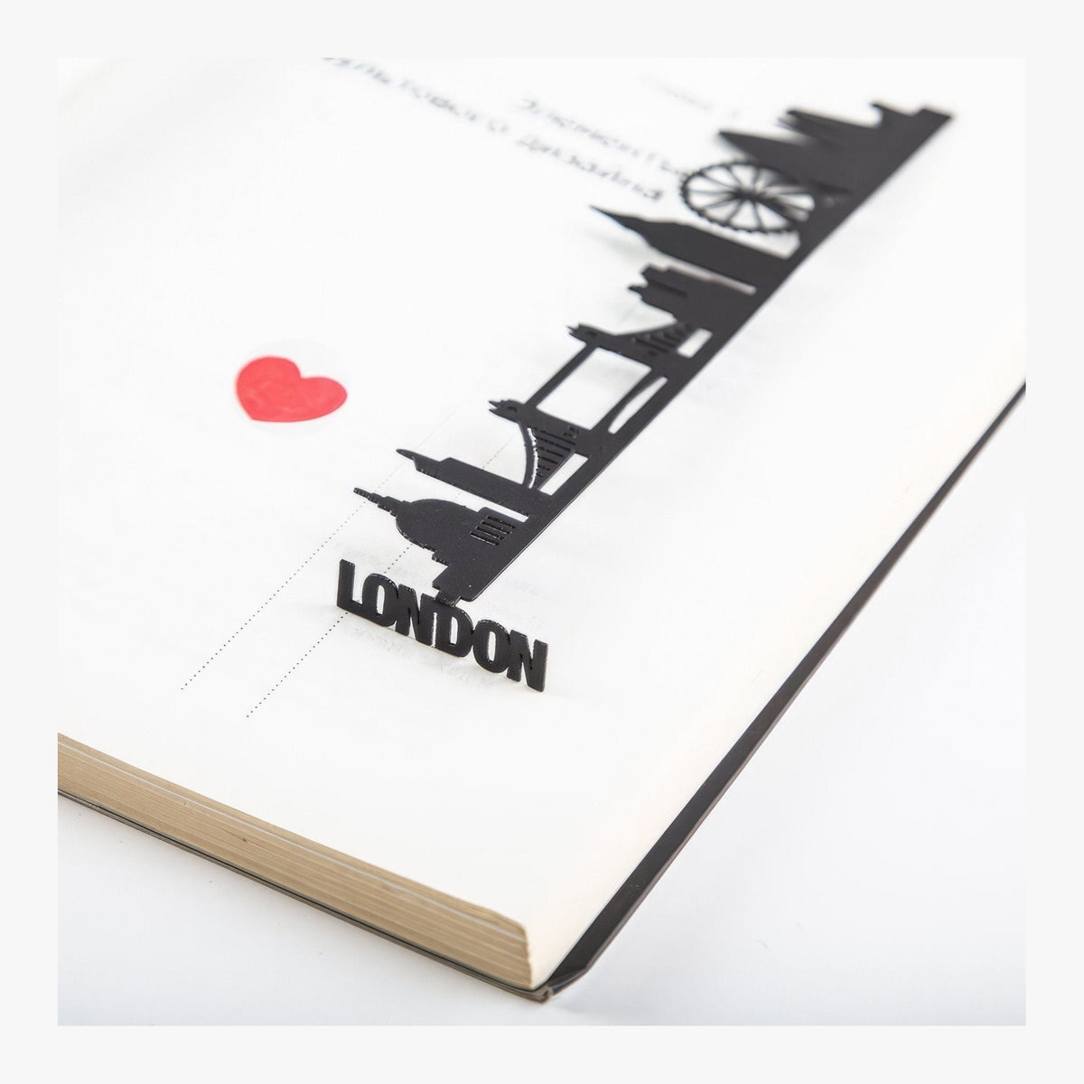 London metal bookmark resting on the pages of an open book